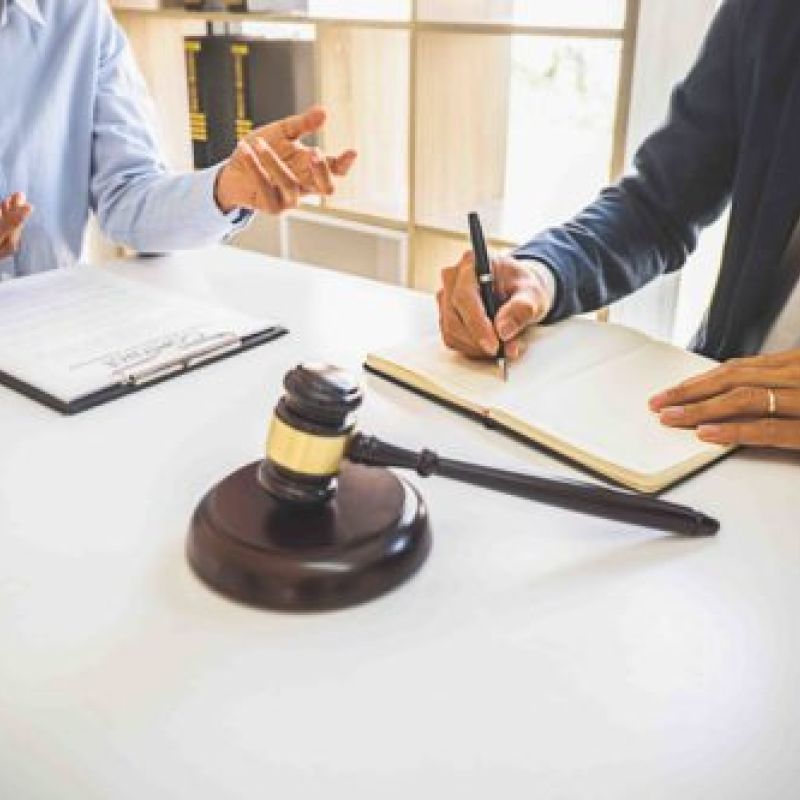 Lawyers discussing a case with documents and gavel on the table, symbolizing legal consultation and decision-making.