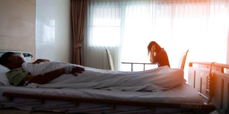 a man laying in a hospital bed next to a woman