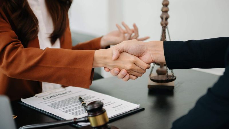a couple of people shaking hands over a desk
