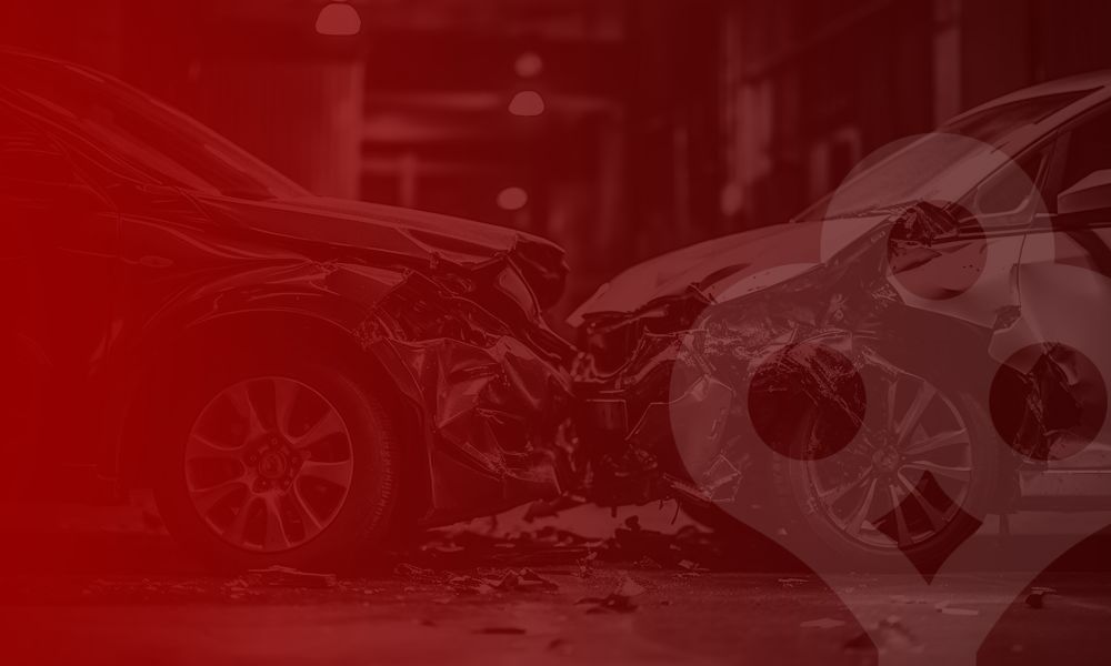 Two cars in a head-on collision on a street, with significant front-end damage and debris around.