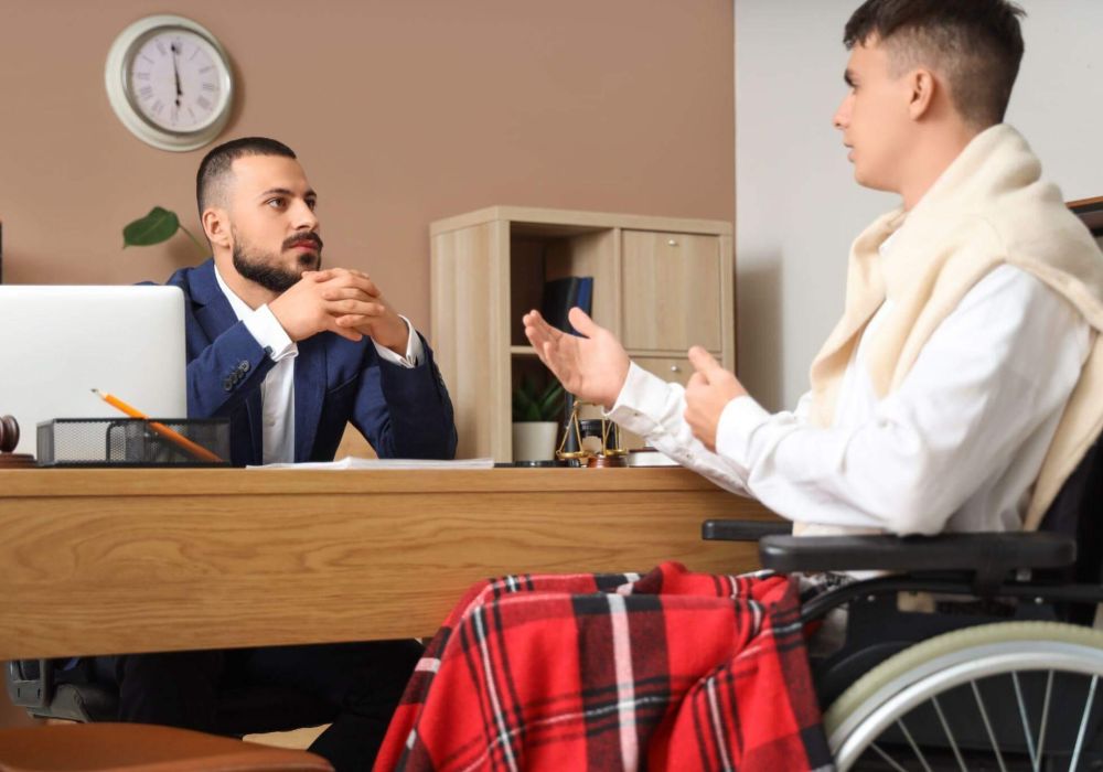 a man in a wheelchair talking to another man