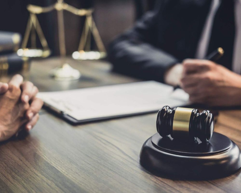 two people sitting at a table in front of a judge's gavel