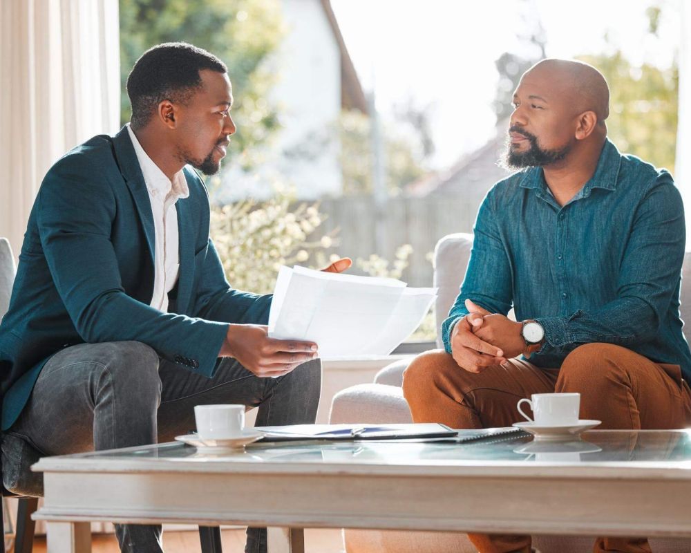 a couple of men sitting on top of a couch