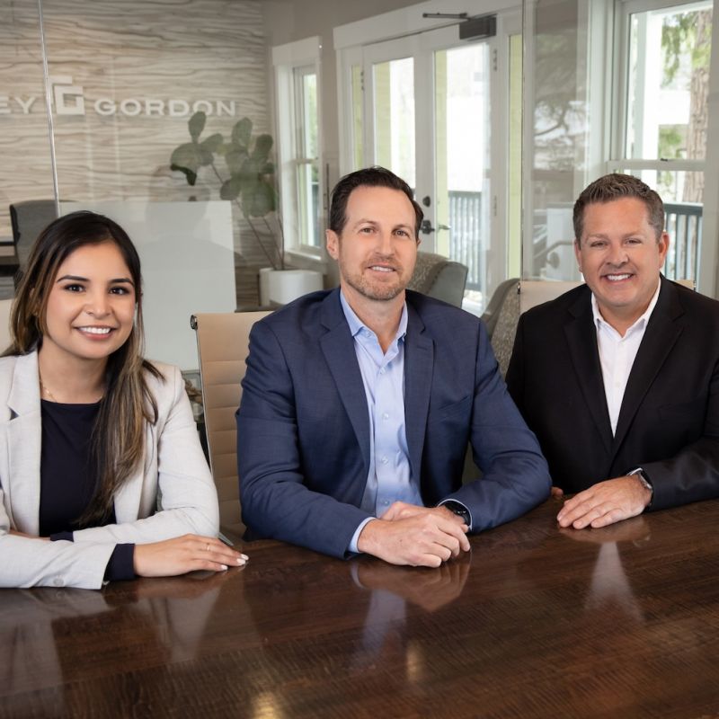 Attorneys from Redkey Gordon Law are in a conference room at the Redkey Gordon law office, smiling and seated at a table.