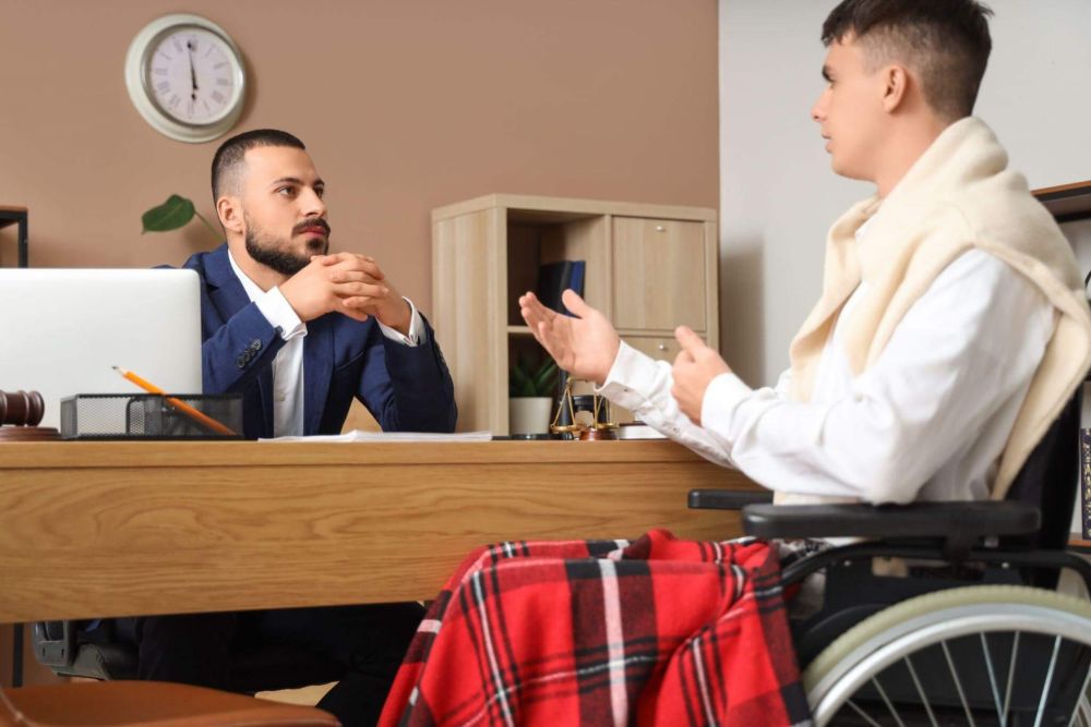 a man in a wheelchair talking to another man