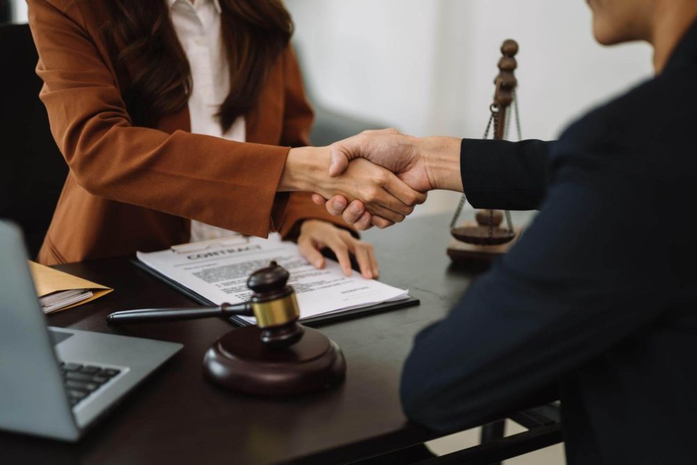 a couple of people shaking hands over a desk