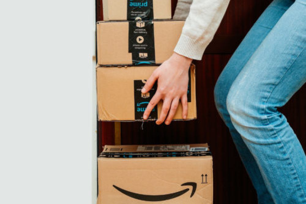 Person stacking Amazon Prime packages inside a closet.