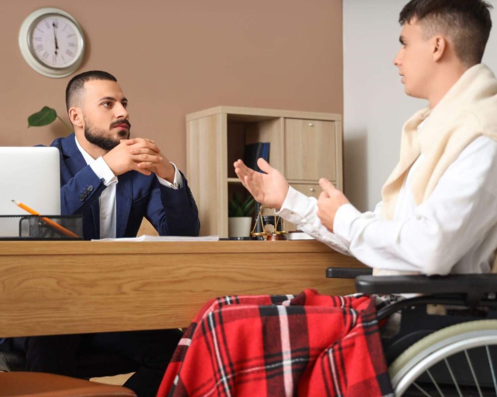 a man in a wheelchair talking to another man