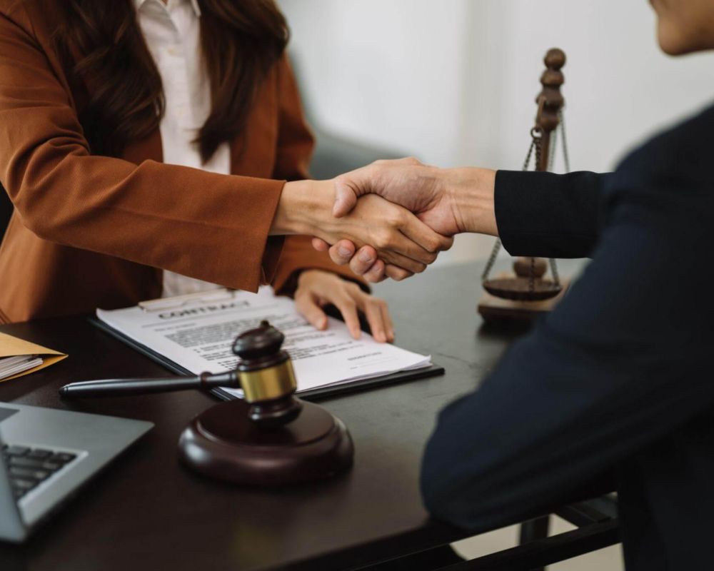 a couple of people shaking hands over a desk