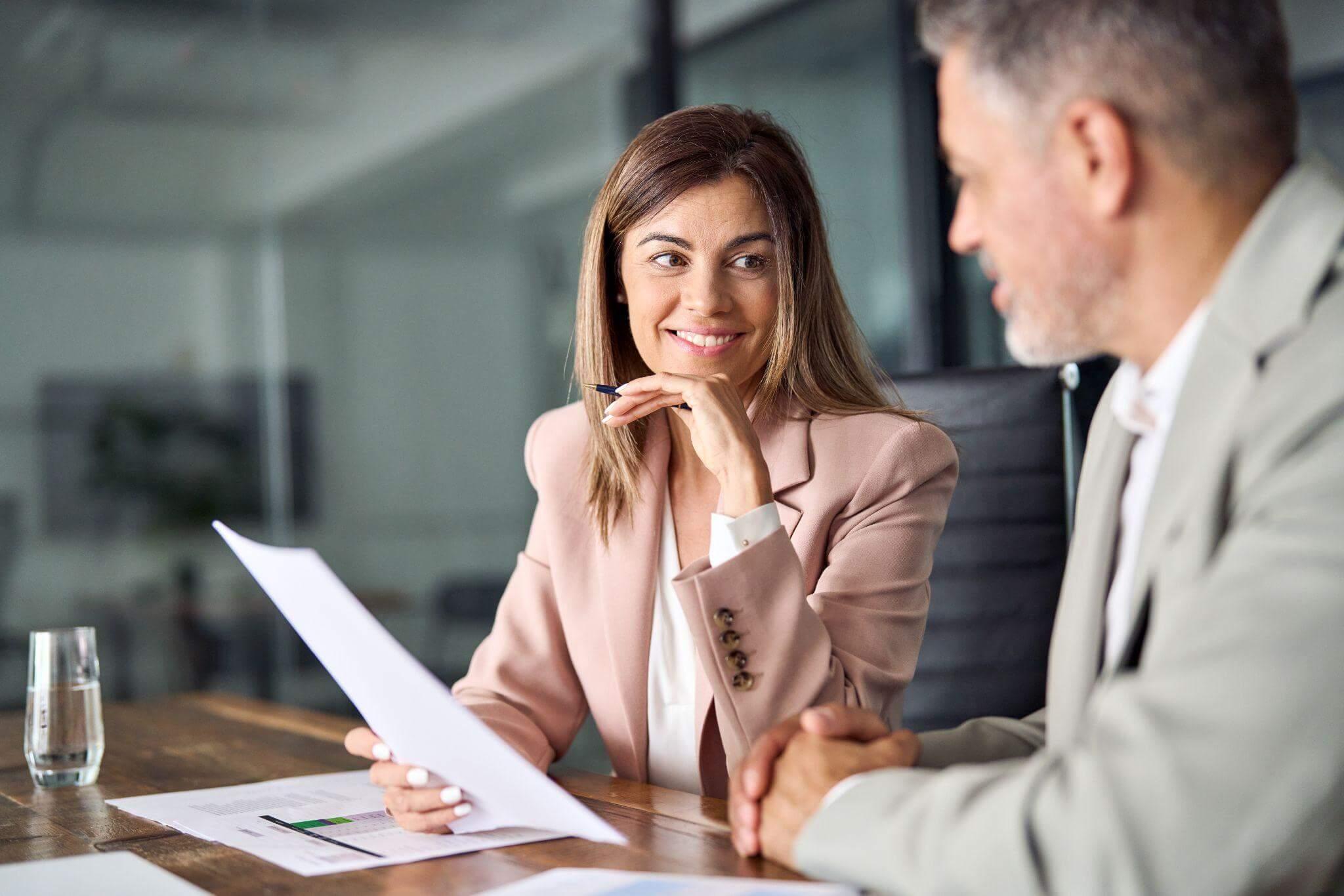 a couple of people sitting at a table reviewing legal documents