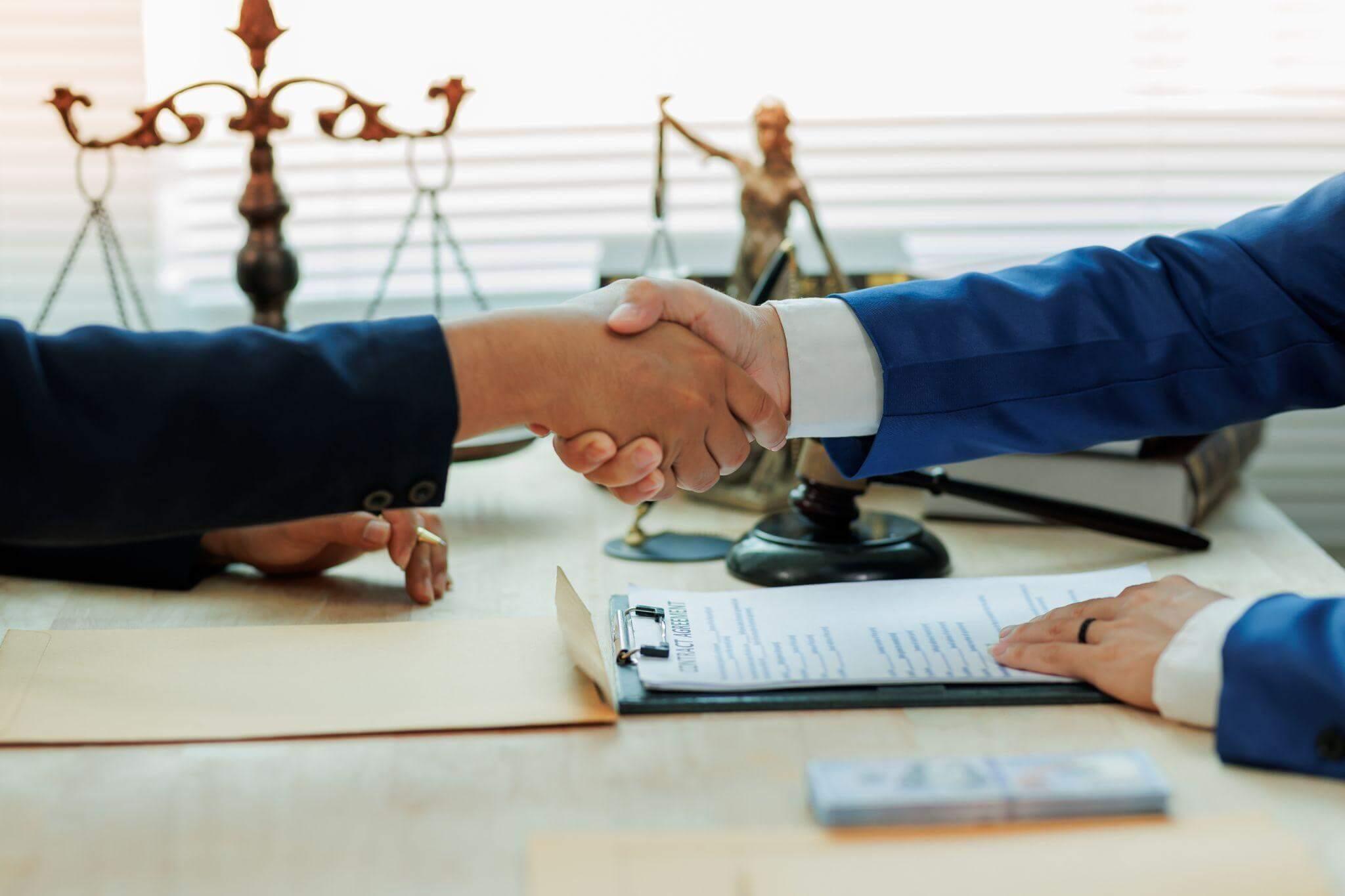 a couple of people shaking hands over a piece of paper