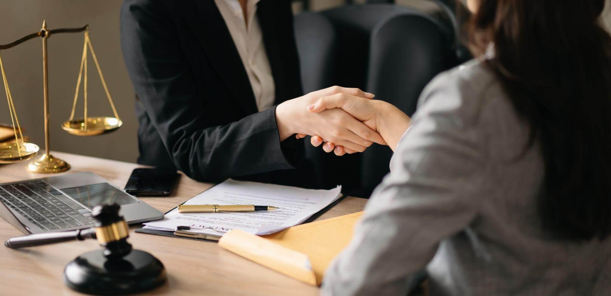 Two people shaking hands after negotiating a truck accident