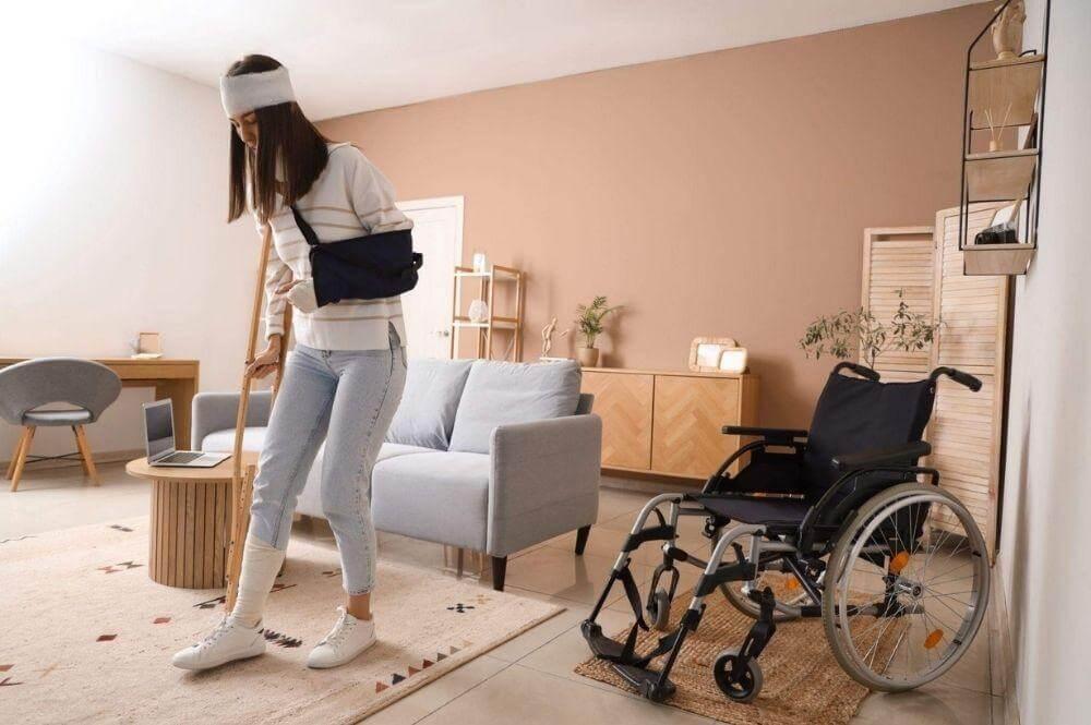 Woman standing in a living room next to a wheelchair