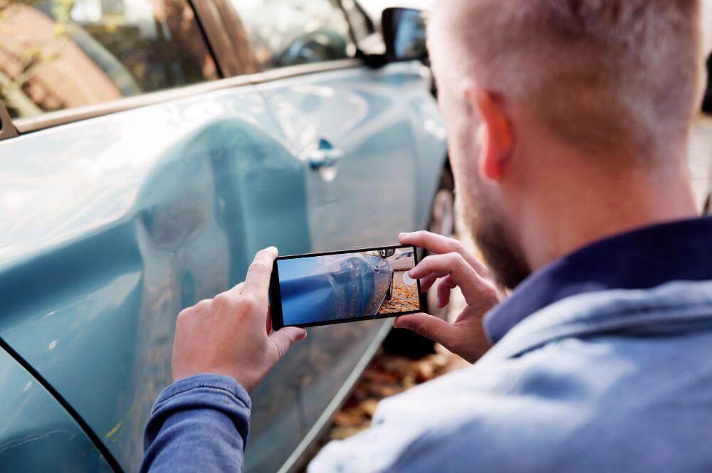 Man documents car accident scene for review by L