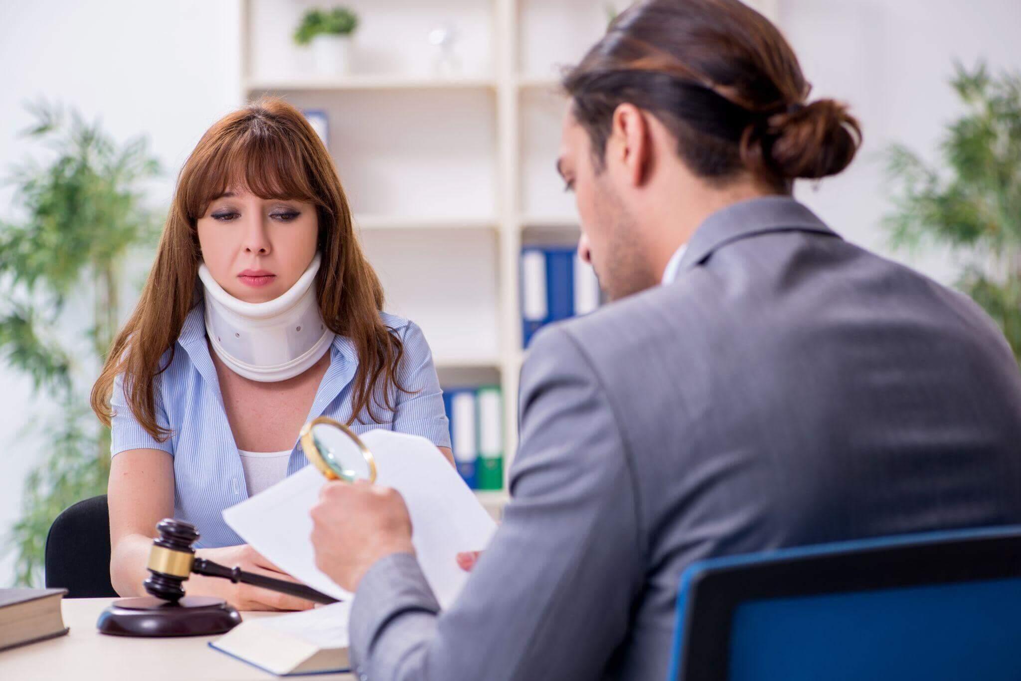 Woman client sits at desk in front of judge in