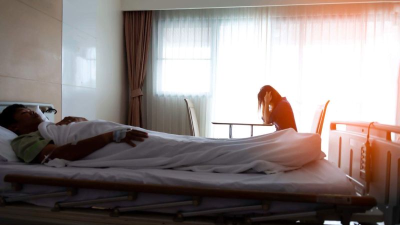 a man laying in a hospital bed next to a woman
