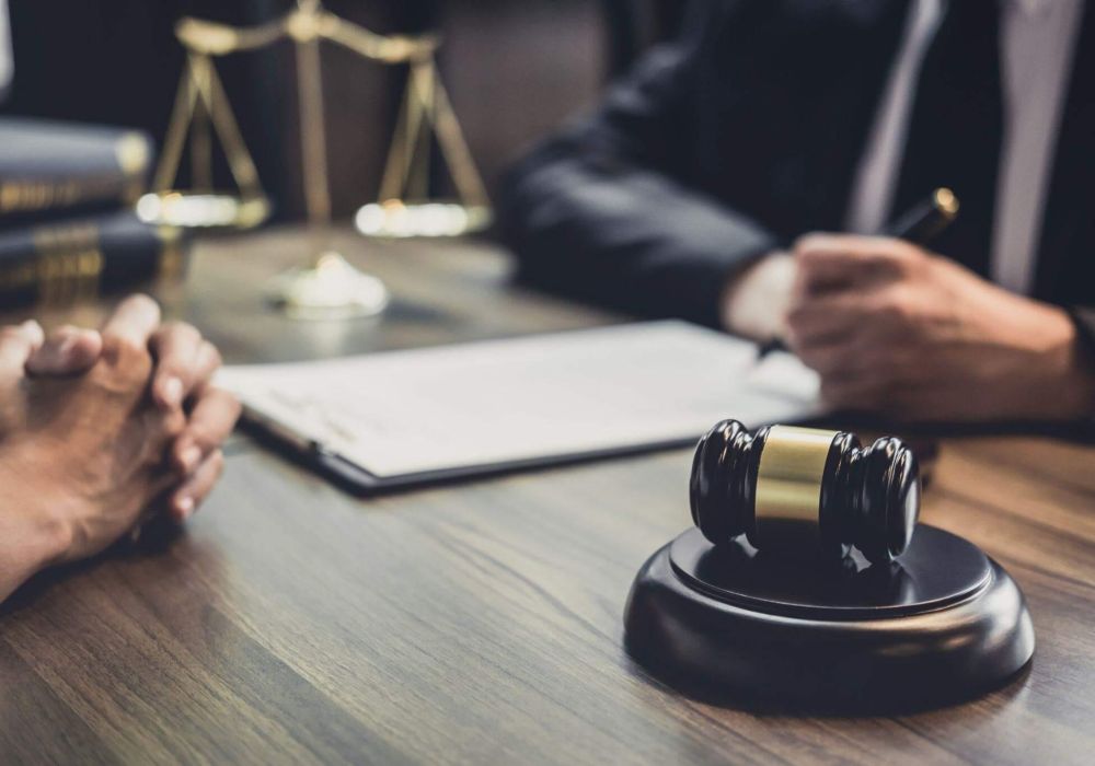 two people sitting at a table in front of a judge's gavel