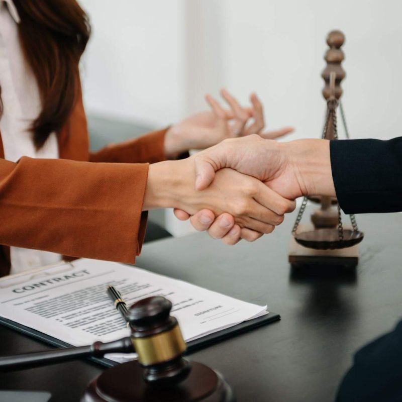 a couple of people shaking hands over a desk