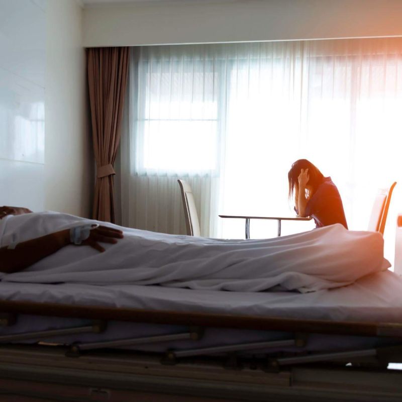 a man laying in a hospital bed next to a woman